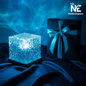 A blue water ripple projector lamp placed next to a premium black gift box with a silk ribbon.